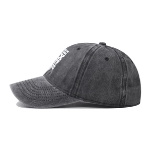 Macro detail of washed cotton baseball cap showing white printed text and fabric texture