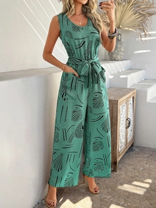 Detail of green sleeveless jumpsuit with waist tie and black line pattern pockets