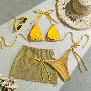 Detail of yellow three-piece bikini set with sequin mesh skirt and summer straw hat