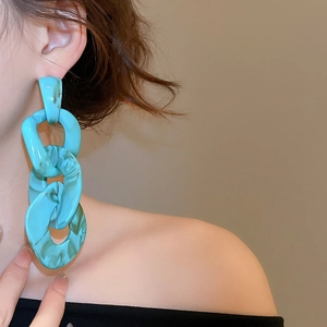 Detail view of turquoise acrylic chain drop earrings with marble texture on model