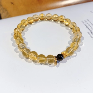 Detailed close-up of natural citrine and garnet flower bracelet on a white book