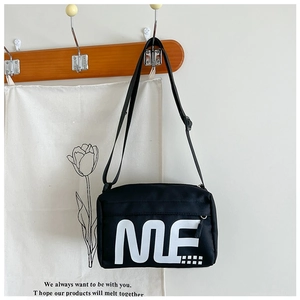 Détail du sac bandoulière rectangulaire noir avec imprimé ME et bandoulière réglable