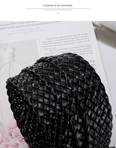 Macro shot of black glossy braided PU leather belt texture on a stylish magazine background