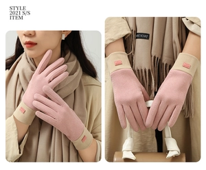 Detail of pink and beige winter touchscreen gloves with a fashion label and warm texture