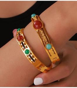 Detailed shot of vintage gold-plated titanium steel bangles with colorful stone inlays
