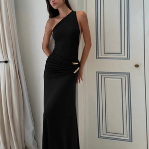 Détail de la robe noire élégante à une épaule avec taille plissée et boucle en métal doré