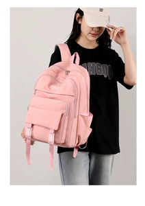 Zaino rosa per studenti con design multi-tasche indossato da modella per look casual