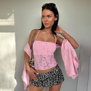 Detail eines rosa Spitzen-Halter-Crop-Tops kombiniert mit einem Leoparden-Faltenrock