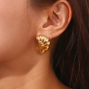 Detail of model wearing a 18K gold plated semicircle shell textured stud earring