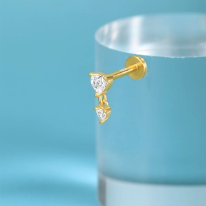 Macro detail of S925 sterling silver gold stud earring with double heart cubic zirconia