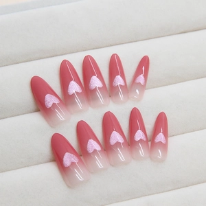 Pink gradient cat-eye press-on nails with 3D heart design and long almond shape