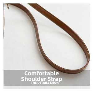 Detailed close-up of brown leather shoulder strap with fine stitching for handbag