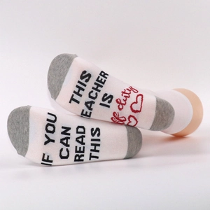 Detail of cotton socks with funny text 'If you can read this' and 'This teacher is off duty'