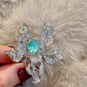 Luxurious silver flower brooch with oval aqua gemstone and sparkling crystals on fur