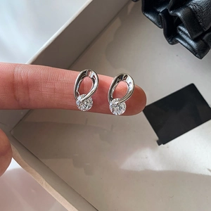 Silver drop-shaped hollow earrings with large round cubic zirconia stones on display