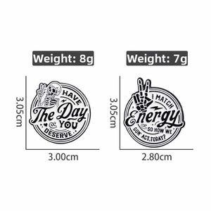 Detail of Halloween enamel pins showing skull motifs and engraved lettering weight specs