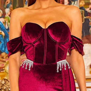 Off-shoulder burgundy velvet evening dress with corset bodice and rhinestone tassels