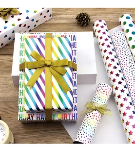 Detail of colorful metallic gift wrapping paper with laser dots and stripes on wood