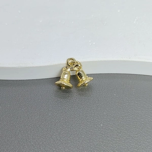Macro shot of gold double bell charm with bow detail for DIY jewelry making