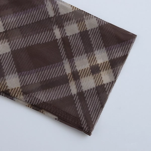 Detailopname van bruine en beige ruitjesstof met gedetailleerd stiksel aan de rand