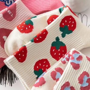 Pink and white patterned crew socks with strawberry, heart, and leopard knit designs