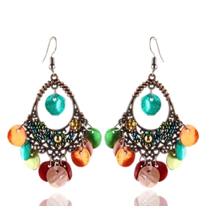 Dettaglio di orecchini bohémien vintage con paillettes colorate e montatura in bronzo