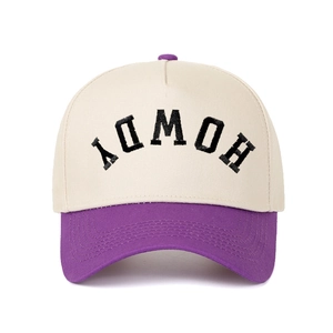 Close-up of HOWDY 3D embroidery on a cream and purple two-tone five-panel trucker hat