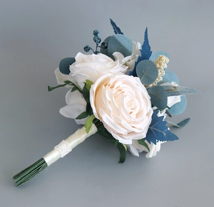 Detail of bridal bouquet handle with cream ribbon lace and realistic faux white roses