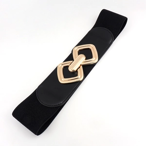 Détail de la boucle métallique dorée sur une large ceinture élastique noire pour femme