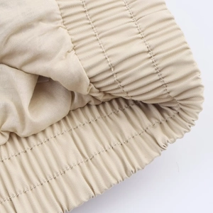 Detailed macro view of the elastic waistband on a beige waterproof short windbreaker jacket