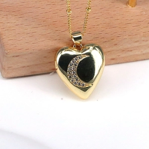 Close-up of golden heart pendant featuring a diamond-set moon pattern on a chain