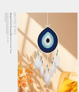 Detail of bohemian evil eye dreamcatcher with native style feathers and wood beads
