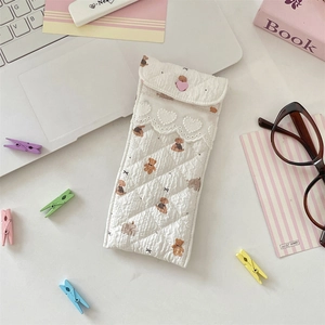 Quilted cream glasses pouch with cute bear print and lace trim on a cozy desk setup
