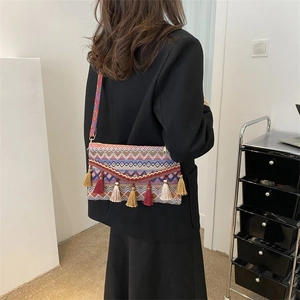 Detail view of Bohemian tassel crossbody bag with colorful ethnic patterns and woven strap