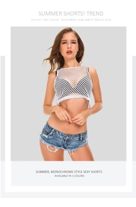 Nahaufnahme der Jeans-Shorts mit Fransen und modischem weißem Netz-Oberteil