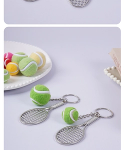 Macro shot of silver tennis racket and colorful flocked ball keychain pendants