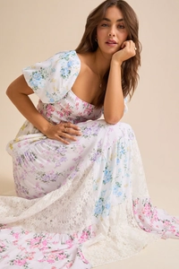 Gros plan d'une robe fleurie blanche avec manches bouffantes et détails de dentelle fine