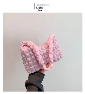 Detail shot of light pink textured bubble bag featuring 3D pleated surface fabric