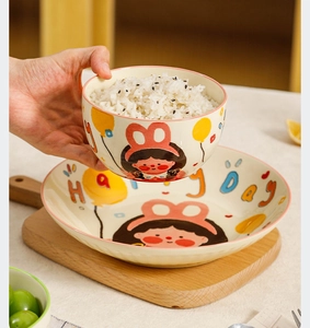 Détail d'un ensemble bol et assiette en céramique avec dessin animé et texte Happy Day