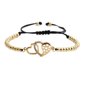 Detail of adjustable gold bead bracelet featuring interlocking double heart charms with crystals