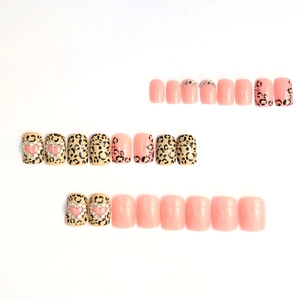 Pink press-on nail set featuring leopard print patterns and rhinestone heart accents