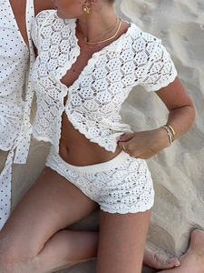Detail of crochet knit texture on beige short sleeve buttoned top and shorts beach set