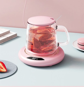 Macro detail of pink electric cup warmer with glass mug and digital temperature display