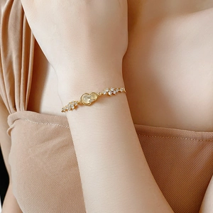 Nahaufnahme des goldenen Hulu Armbands mit Zirkonia und Schleife am Handgelenk