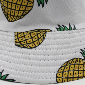 Close-up of pineapple print on white cotton bucket hat with reinforced stitched brim