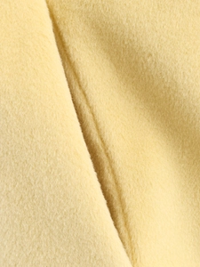 Detailed macro shot of the thick yellow wool fabric texture with natural soft folds