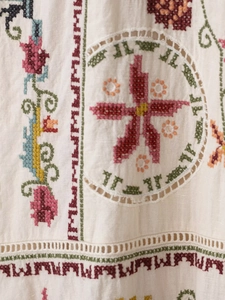 Detail of bohemian embroidery and intricate cutwork on breathable linen-cotton fabric