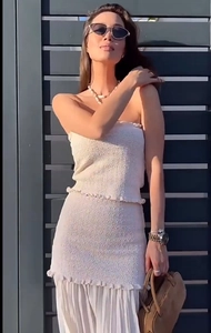 Détail du haut bandeau en tricot et jupe plissée beige à empiècements sur mannequin femme