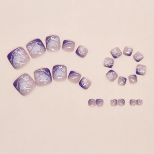 Detail of lavender gradient press-on toenails with flower patterns and golden glitters