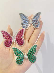 Macro detail of luxury butterfly brooches with colorful zircon stones and micro-pave setting